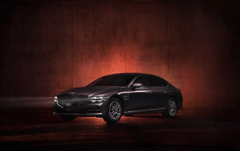 Dark grey luxury sedan in a dimly lit studio
